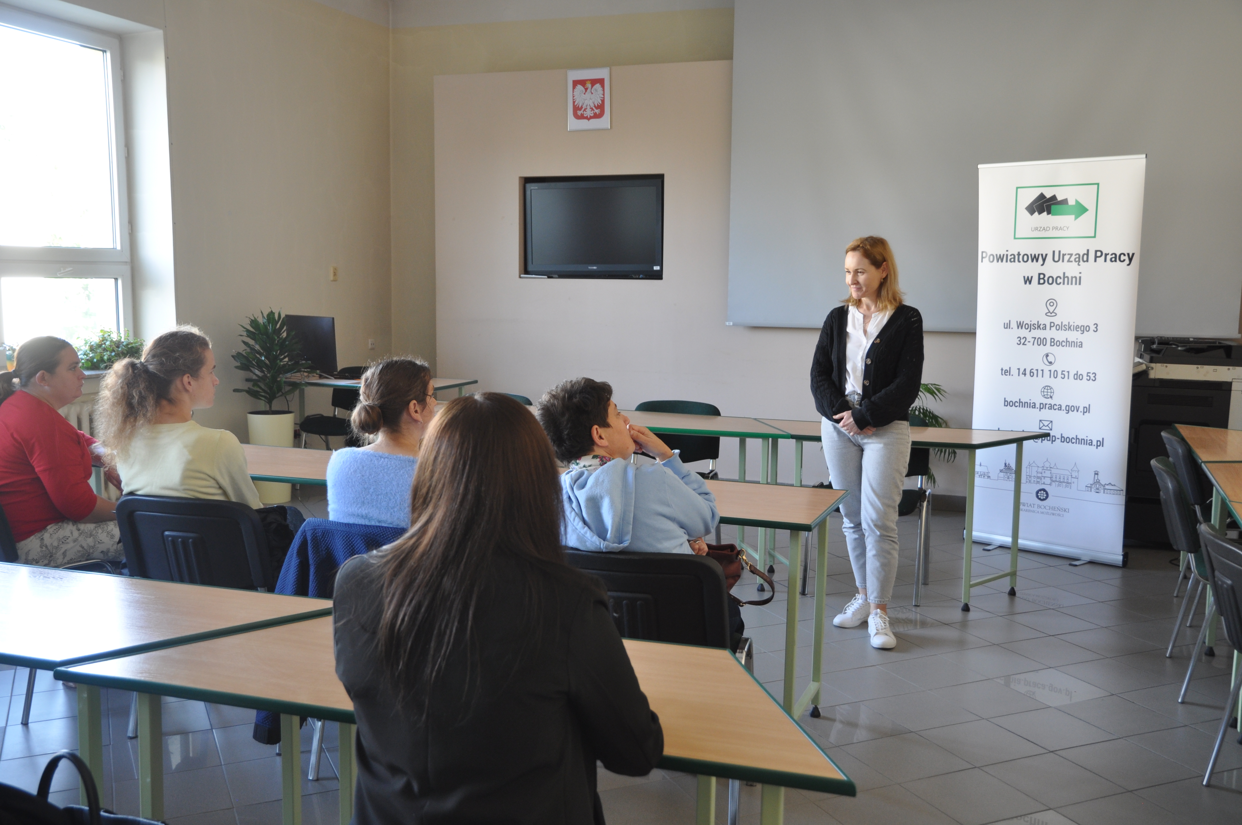 Sala konferencyjna, prowadząca oraz uczestnicy spotkania 